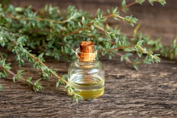 Een Transparante Fles Etherische Olie Met Verse Tijmtakjes Een Tafel — Stockfoto