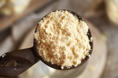 Tahta kaşıkta bir yığın beyaz protein tozu, üst manzara.