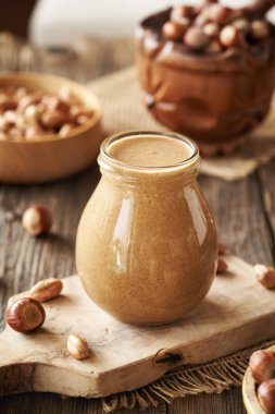 Masadaki cam kavanozda ev yapımı fındık ezmesi.