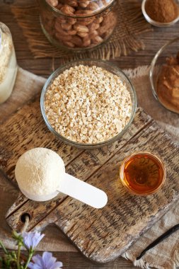 Beyaz protein tozu, yulaf ezmesi, fındık ezmesi, tarçın ve akçaağaç şurubu. Ev yapımı atıştırmalıklar için malzemeler.