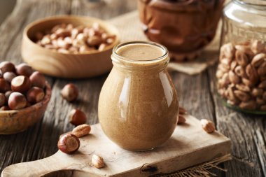 Ev yapımı fındık ezmesi ve fındık dolu cam kavanoz.