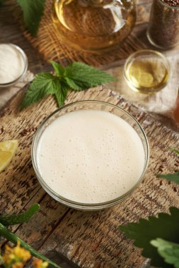 Ev yapımı keten tohumu jeli, argan yağı, elma sirkesi, ısırgan otu ve kakao glukozu ile yapılan bir kase DIY şampuanı. Kaka bakımı yok..