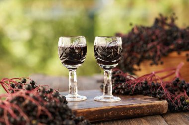 Yazın taze böğürtlen ve iki shot bardakta siyah yaşlı şurubu.