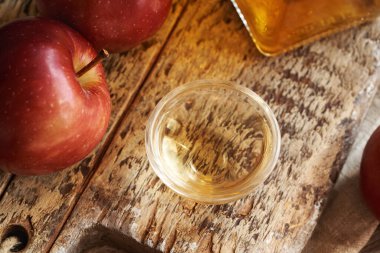 Elma şarabı sirkesi, cam bir kasede, ahşap bir masada, yakın çekim.