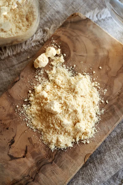 Tahta kesme tahtasında beyaz protein tozu, üst manzara.