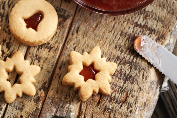 Ev yapımı Linzer Noel kurabiyelerini kırmızı çilekli marmelatla dolduruyorum.