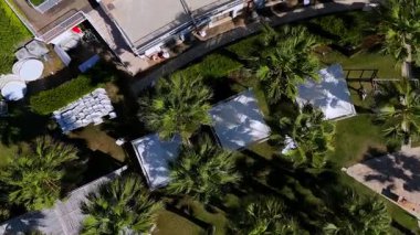 Aerial drone shot of tropical palm garden with pergolas in luxury resort