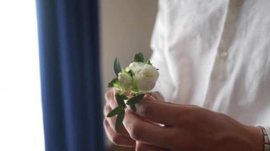 Video of groom preparing with boutonniere during wedding morning