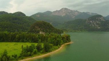 Turkuaz göl ve dağlarla kaplı orman kıyı şeridi manzarası