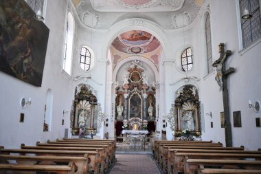 Fussen, Bavaria, Germany June 28, 2025. Interior of St. Mang Basilica showing the nave with wooden pews, ornate baroque altar, frescoed ceiling and religious artwork inside the historic church.