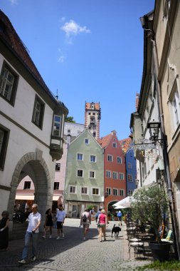 Tourists walking along historic old town street with colorful houses and tower in Fussen Bavaria Germany on June 28 2025 Editorial use only