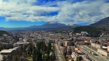 Fransa 'daki Gap şehrinin hava manzarası. Konut binaları, yeşil alanlar ve açık mavi gökyüzü altındaki dağ manzarası.