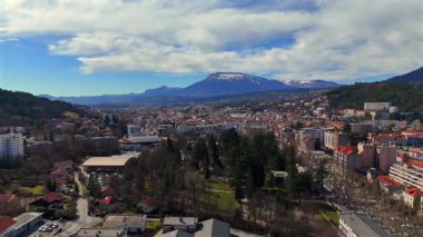 Fransa 'nın güneyindeki Gap şehrinin hava manzarası. Ana caddedeki yerleşim alanları parkları ve bulutlu gökyüzünün altındaki dağlar.