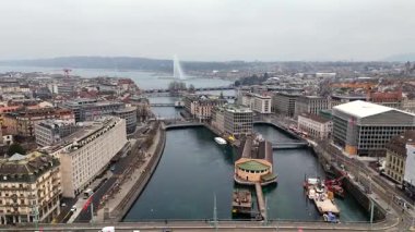 Bulutlu bir kış gününde Jet dEau ve Bains des Paquis ile Cenevre rıhtım manzarası
