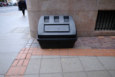 Büyük siyah plastik konteyner grit veya tuz ile kaldırımda. Kış aylarında buz veya kar durumunda Konsey karfl›l›¤›.