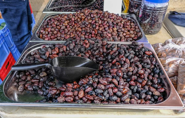 Bir sokak mar bir tezgahüzerinde siyah zeytin dolu metal kaplar