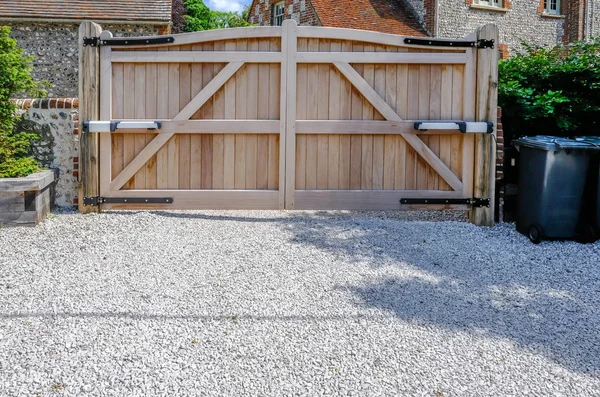 Large wooden entry electric gates with stone driveway. — Stock Photo, Image