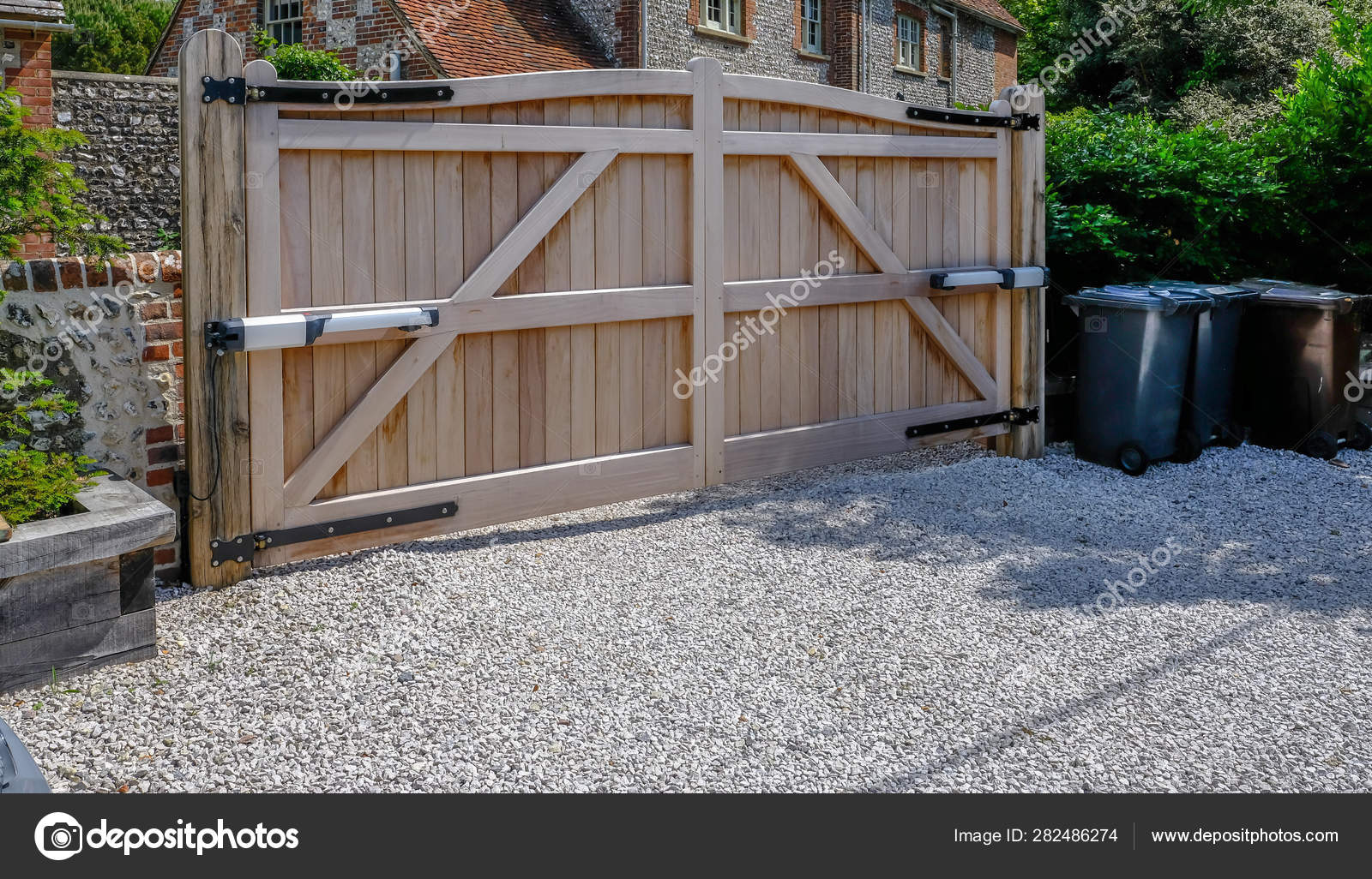 Large Wooden Entry Electric Gates With Stone Driveway