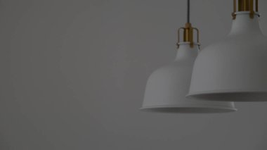 Modern bir iç mekanda asılı altın aksanlı şık beyaz kolye lambaları. Çağdaş ev ışıklandırması öğesi, mimari, iç dekorasyon, minimalist tarz, arka plan ve yaşam tarzı kavramları için mükemmel.