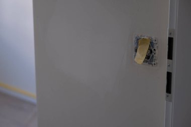 Tadilat aşamasında olan bir duvarda koruyucu film bantlı elektrik prizi. İnşaat, onarım, ev geliştirme ve DIY kavramları için elverişli.
