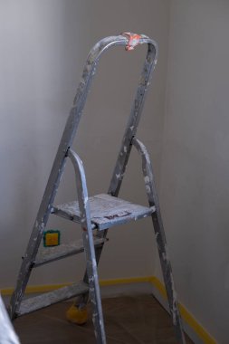 Daire yenileme sırasında duvarda boya izleri olan metal merdiven. DIY, İnşaat, Ev Geliştirme, Boyama, Gayrimenkul, Tasarım, Tamir ve Yenileme Temaları İçin Uygun.