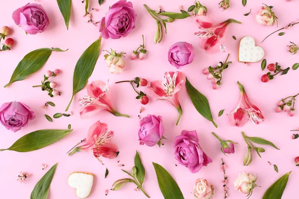 バラの芽 ユリの花 ピンクの背景の緑の葉で作られた花のパターン フラットレイアウト トップビュー ストック写真