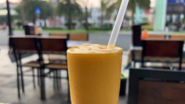 Bu dinamik stok videosundaki canlı seyahat sahnelerini keşfedin Macro vitrin mango suyu, bir bardak ve tropik bir cennetteki denizi yakına dalıp bu büyüleyici görüntü üzerine dalın..