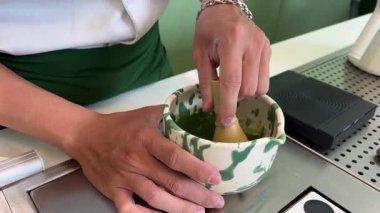 Bambu çırpıcı ile taze yeşil çay demlemek için geleneksel Japon usulü çay çırpmak köpüklü dokular ve sakin deneyimler yaratır. Yüksek kalite 4k görüntü