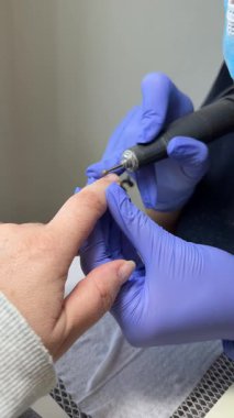 Manikür ustası eldivenler içinde müşterilerinin tırnaklarına kırmızı jel sürerek güzellik salonunu boyuyor. Kadın elleri için profesyonel bakım. Güzellik salonu. Tırnak bakımı tedavisi. Yüksek kalite 4k görüntü