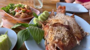 Lezzetli kızarmış balık ya da balık soğan, domates ve limonla birlikte siyah bir tabakta kızarır. Hint usulü baharatlı Kerala balığı ahşap bir masada kızarır. Limon ızgara balığın üzerine sıkılmış. Yüksek kalite 4k görüntü