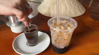 Yoğunlaştırılmış sütlü Vietnam kahvesi yapmak geleneksel bir filtrede bir kafede yakın çekimde. Yoğunlaştırılmış sütle Vietnam kahvesi yapma süreci