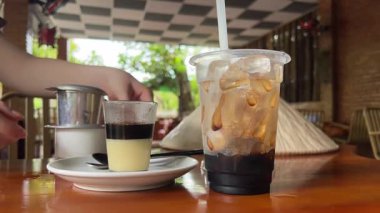 Yoğunlaştırılmış sütlü Vietnam kahvesi yapmak geleneksel bir filtrede bir kafede yakın çekimde. Yoğunlaştırılmış sütle Vietnam kahvesi yapma süreci