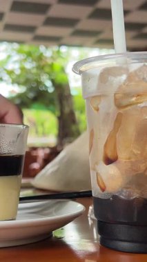 Yoğunlaştırılmış sütlü Vietnam kahvesi yapmak geleneksel bir filtrede bir kafede yakın çekimde. Yoğunlaştırılmış sütle Vietnam kahvesi yapma süreci