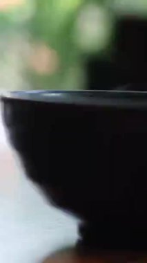 Arka planda siyah seramik bir kasede dumanlı sıcak çorba. Yüksek kalite 4k görüntü