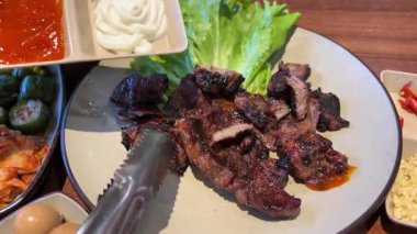 Asya Izgara Lokantası El Lokantası restoranında ızgara domuz eti ve ızgara ızgara ızgara demir ızgara tava. Geleneksel Kore usulü ızgara ızgarada domuz eti. Yüksek kalite 4k