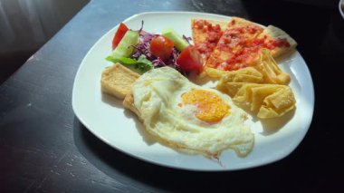 Kahvaltı, yumurtayı sebzelerle birlikte tabağa koydu. Yüksek kalite 4k görüntü