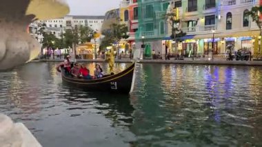 Binanın akşam kanalına bakan turistlerle dolu bir gondol Grand World 'ü geçiyor. Vietnam Phu Quoc Adası 09.05.2025