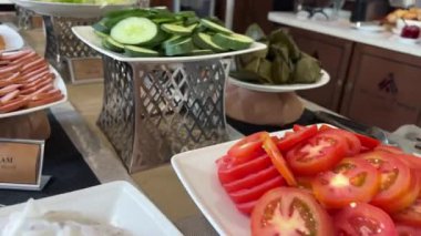 Kırsal ahşap masada taze renkli sebzeler içinde havuç, domates, salatalık ve yapraklı yeşillikler var. Çiftlikten sofraya, sağlıklı yemek, organik yemek ve doğal yaşam tarzı stokları için idealdir. .