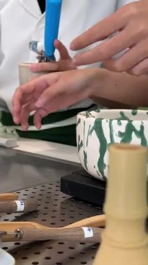 Geleneksel Japon töreninde güzel yeşil çay tozu çırpan bir kadının yaptığı kibrit çayı. Sakinleşme ritüeli denge, farkındalık ve doğal tatlara odaklandı. .