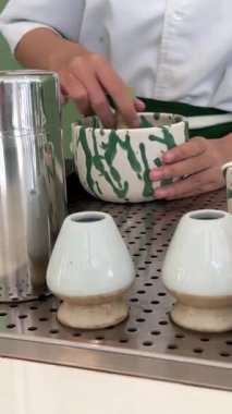 Geleneksel Japon töreninde güzel yeşil çay tozu çırpan bir kadının yaptığı kibrit çayı. Sakinleşme ritüeli denge, farkındalık ve doğal tatlara odaklandı. .