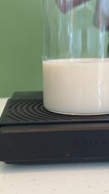 Kadın elleri hamur pişirirken ölçü kabına beyaz süt döküyor. Yüksek kalite 4k görüntü