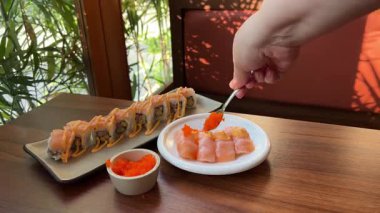 Şefin elleri gümüş balığın üzerinde kırmızı havyar çukurunda. Geleneksel Asya mutfağı. Misafirlere yemek hazırlıyorum. konsept taze, sağlıklı. Japonya 'da lüks bir restoran. dekorasyon yemeği.