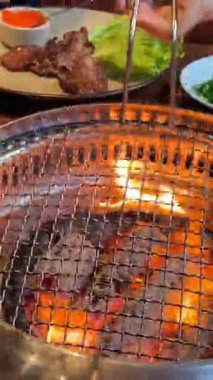 Asya Izgara Lokantası El Lokantası restoranında ızgara domuz eti ve ızgara ızgara ızgara demir ızgara tava. Geleneksel Kore usulü ızgara ızgarada domuz eti. Yüksek kalite 4k