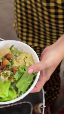 Kırmızı kasede taze sarı erişte, geleneksel Asya sokak yemeği hazırlama, otantik aşçılık tarzı, restoran reklamları, yemek blogları, menüler ve yemek pişirme videoları için mükemmel. Yüksek kalite 4k görüntü