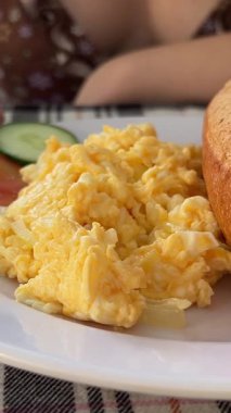 Çırpılmış yumurta, pastırma ve domates. Beyaz tabakta kahvaltı. Güneşli bir sabahta yemek. Yakın plan yumurta. Vietnam banme bun banh mi