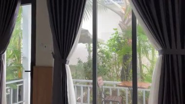 Palmiye ağaçları, balkon bulutlu hava yağmuru tropik gri yatak odası, balkon ve bambu bitkisinin otel manzarasını çitliyor. Minimalist, dinginlik, ahenk, sükunet, sağlık, doğa esinlenmiş..