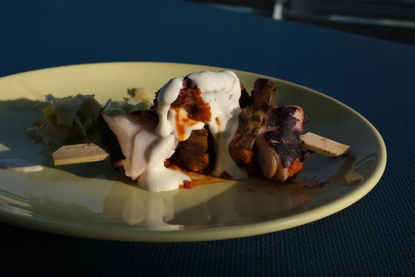 Biftek şişleri açık gri kayrak, taş ya da beton zemin üzerinde bir tabakta şiş kebap. Kopyalama alanı olan üst görünüm.