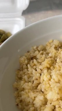 Canlı bir Tayland pirinç yemeğinin yukarıdan görünüşü. Çorba, kızartma ve ızgara şiş dahil olmak üzere birçok renkli yemek. İç mekan aydınlatması altında pürüzsüz kamera hareketleriyle. Yüksek kalite 4k