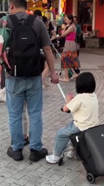 Büyük Dünya. Kanal boyunca yürüyen turistler, çocuklar ve sırt çantalı kadınlar Vietnam Phu Quoc Adası 09.05.2025