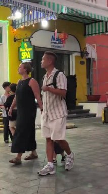 Akşamları turistler dükkanın yakınındaki caddelerde yürürken Asyalı ve Avrupalı insanların Grand World mağazalarına bakıyorlar. Vietnam Phu Quoc Adası 09.05.2025
